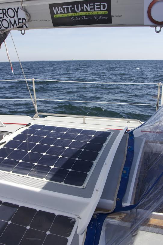Panneau solaire flexible sur un bateau en pleine mer avec le logo Wattuneed.
